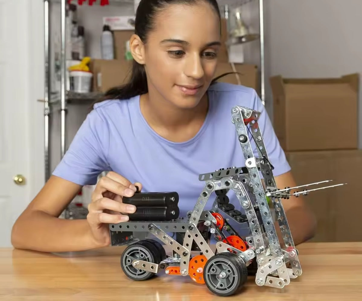 Young girl playing with a mechanical model on a table