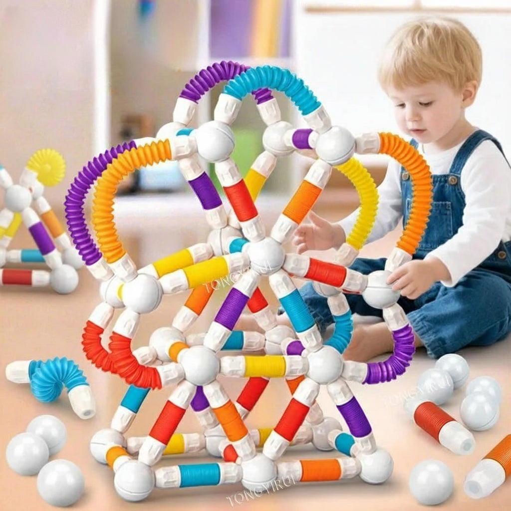 Colorful magnetic building sticks with a child playing with them on a light surface.