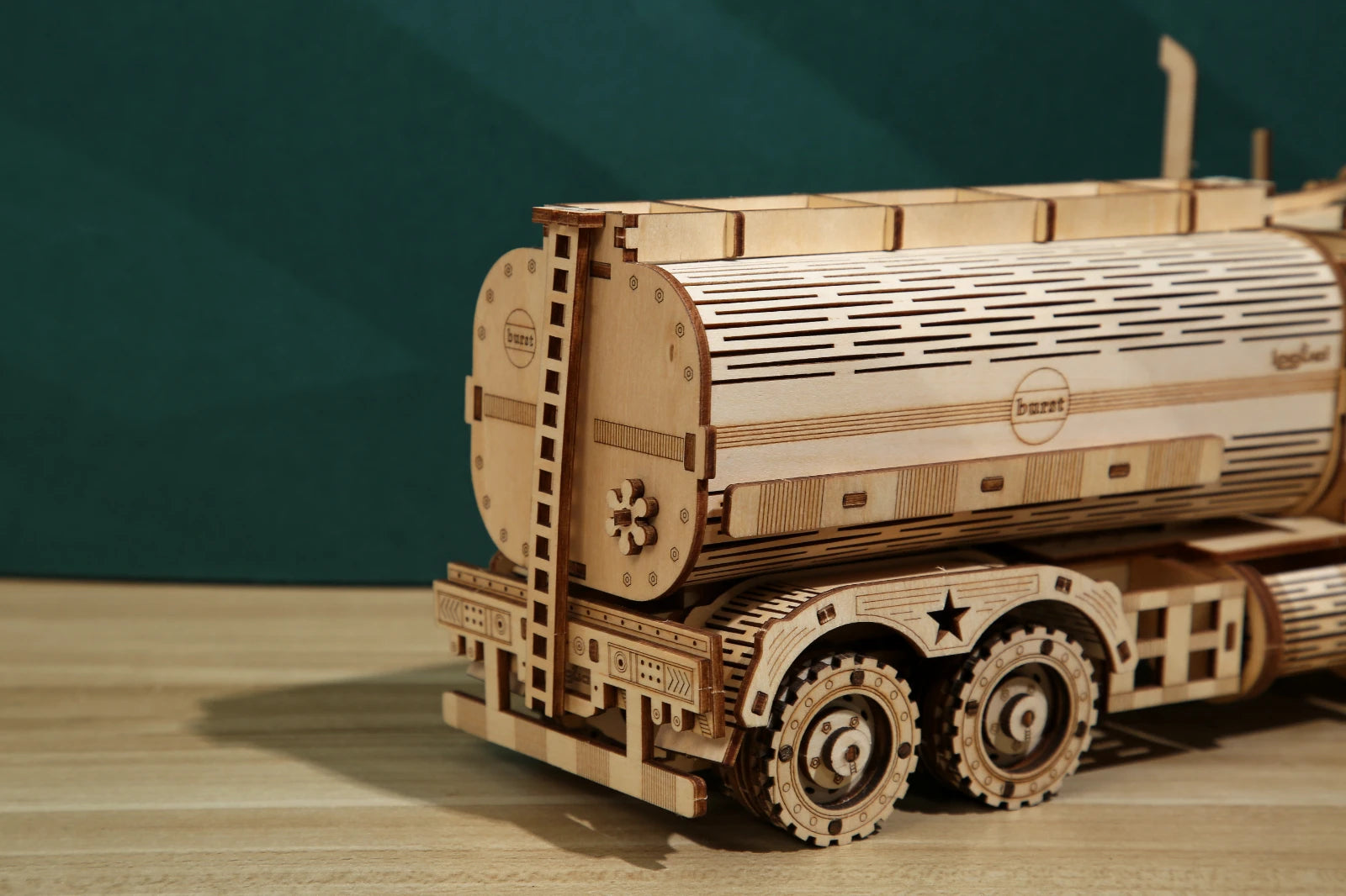 Wooden model of a tank truck on a wooden surface with a dark green background