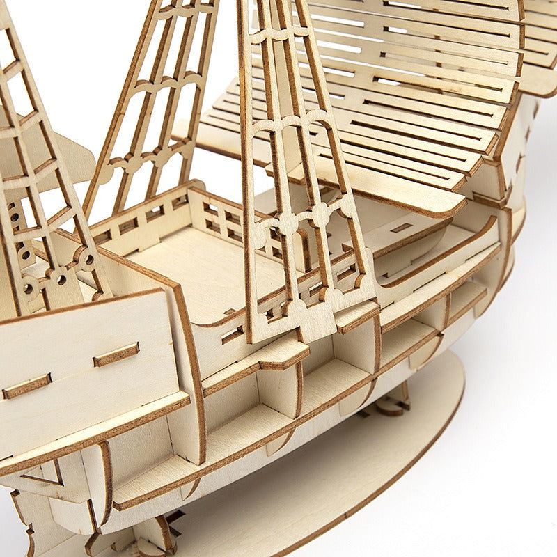Close-up of a wooden ship model kit on a white background