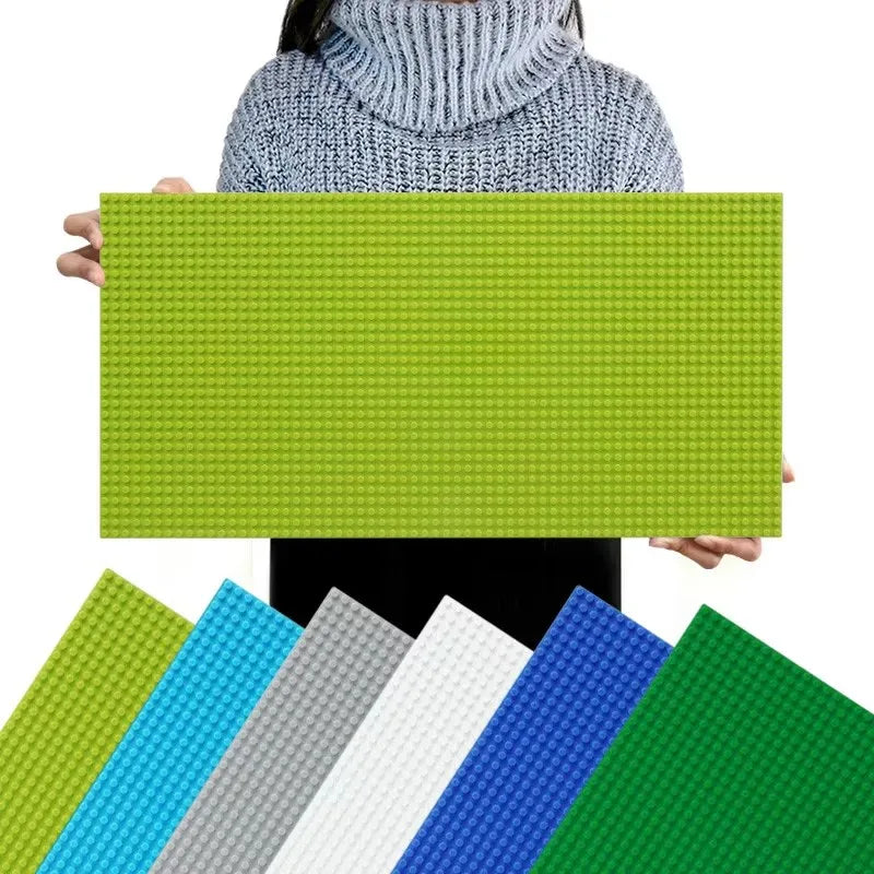 Person holding a green building block baseplate with other color options displayed below.