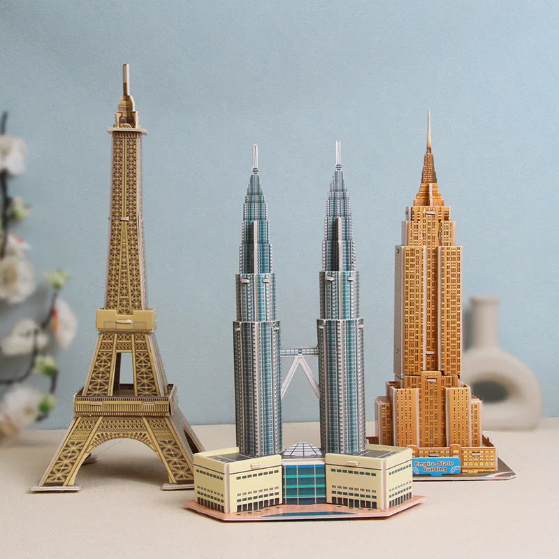 Model of the Eiffel Tower, Petronas Twin Towers, and Empire State Building on a table with a light blue background.