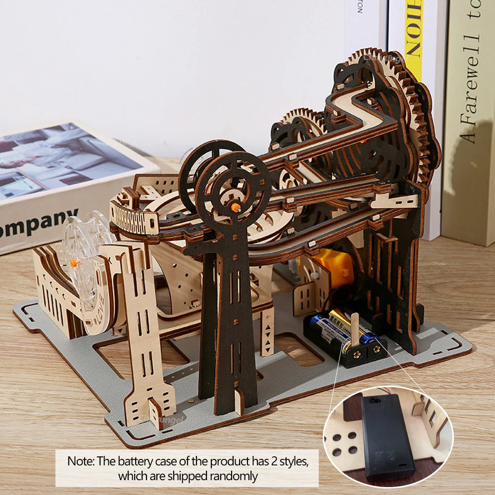 Wooden mechanical model kit on a table with a phone for scale