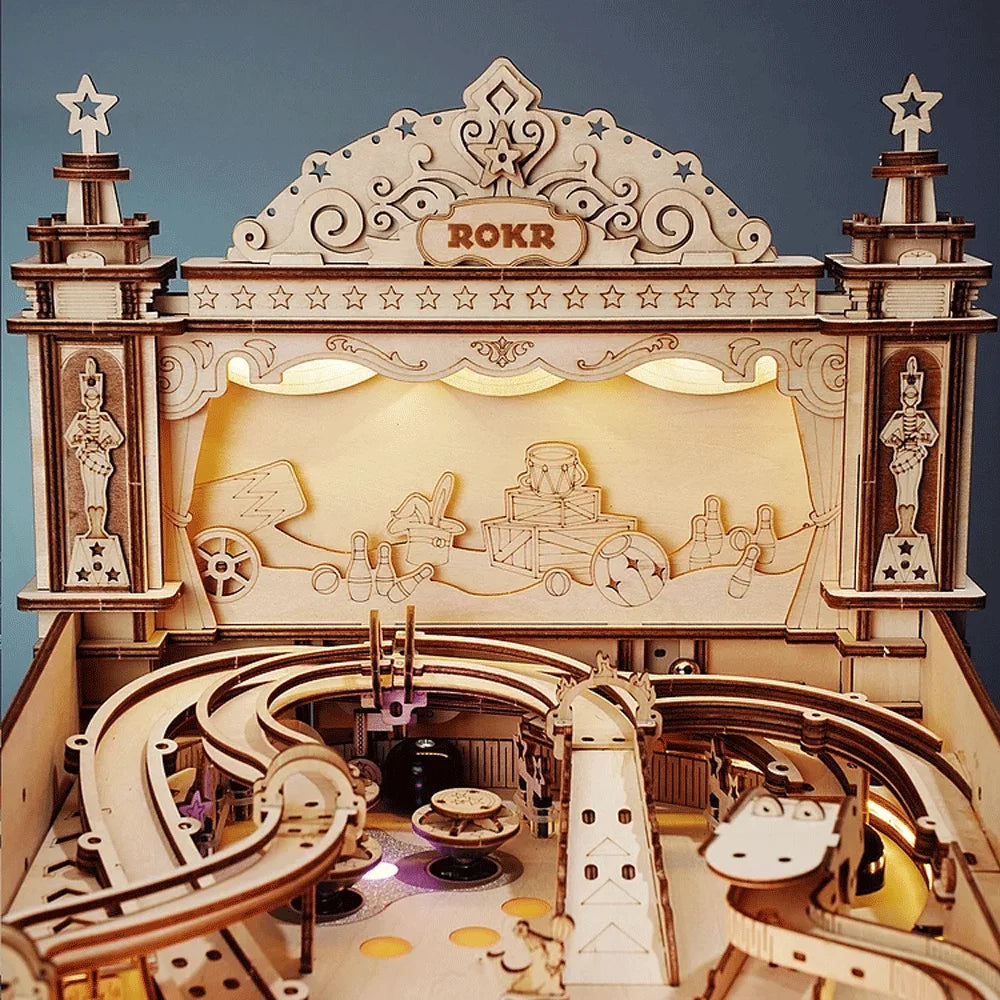 Wooden ROKR toy set with a stage and mechanical figures on a dark blue background