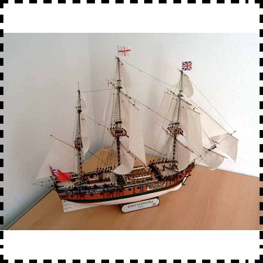 Model ship on a wooden surface with a plain background