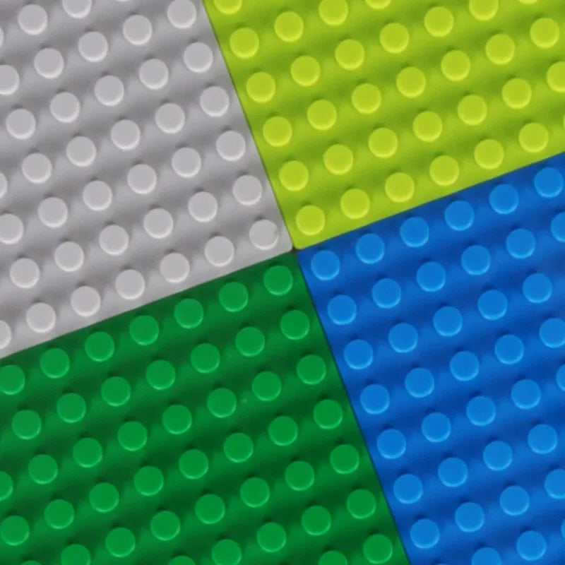 Four colorful building block bases in gray, green, blue, and green.