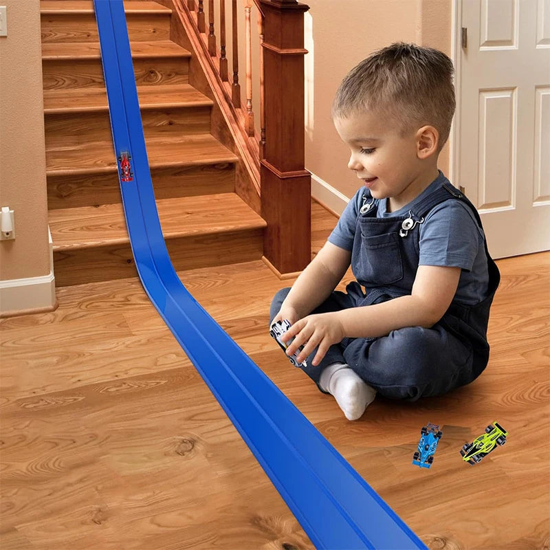 Child playing with a toy car track on a wooden floor