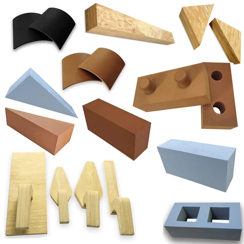 Collection of various wooden architectural model pieces on a white background
