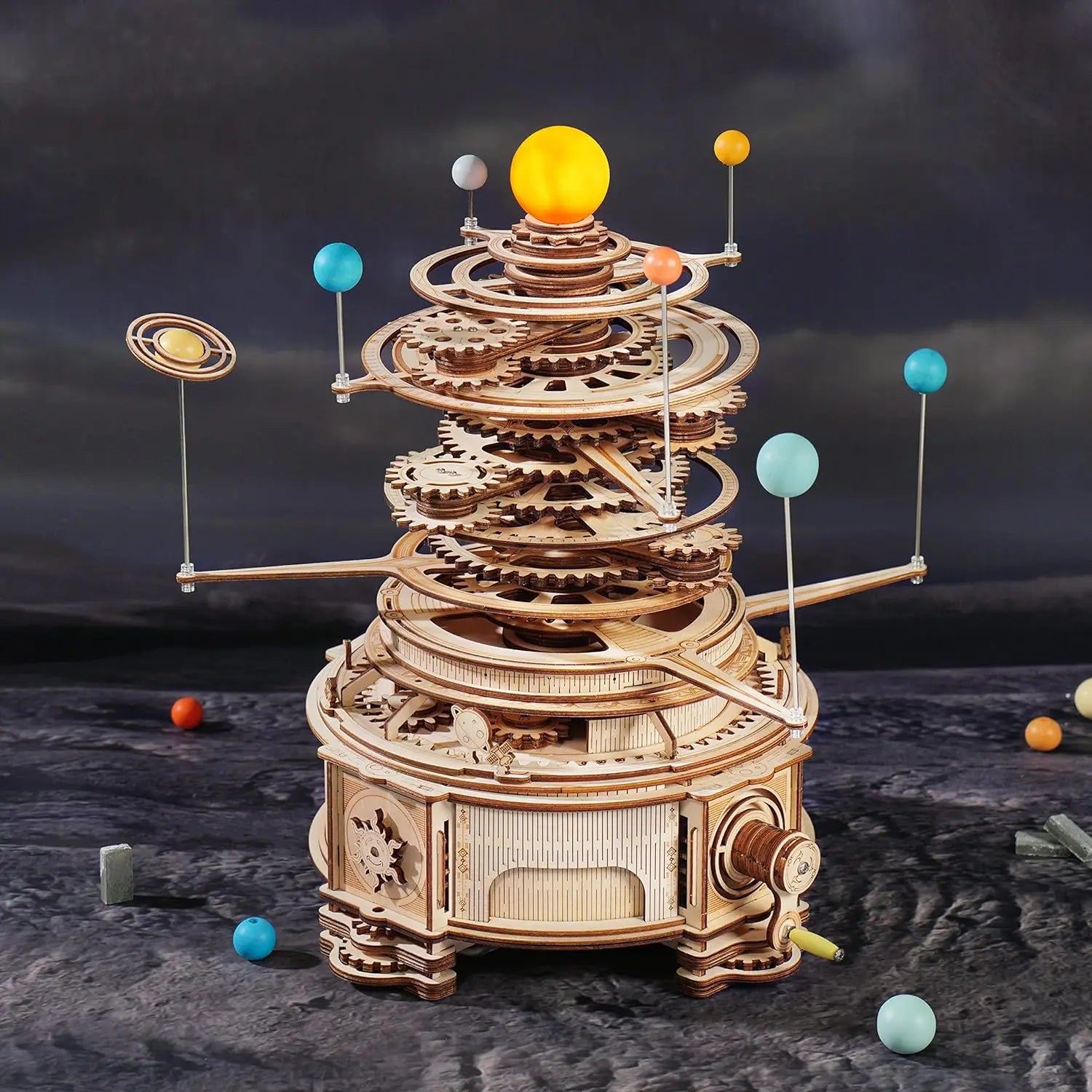 Wooden model of a solar system with planets and gears against a dark background