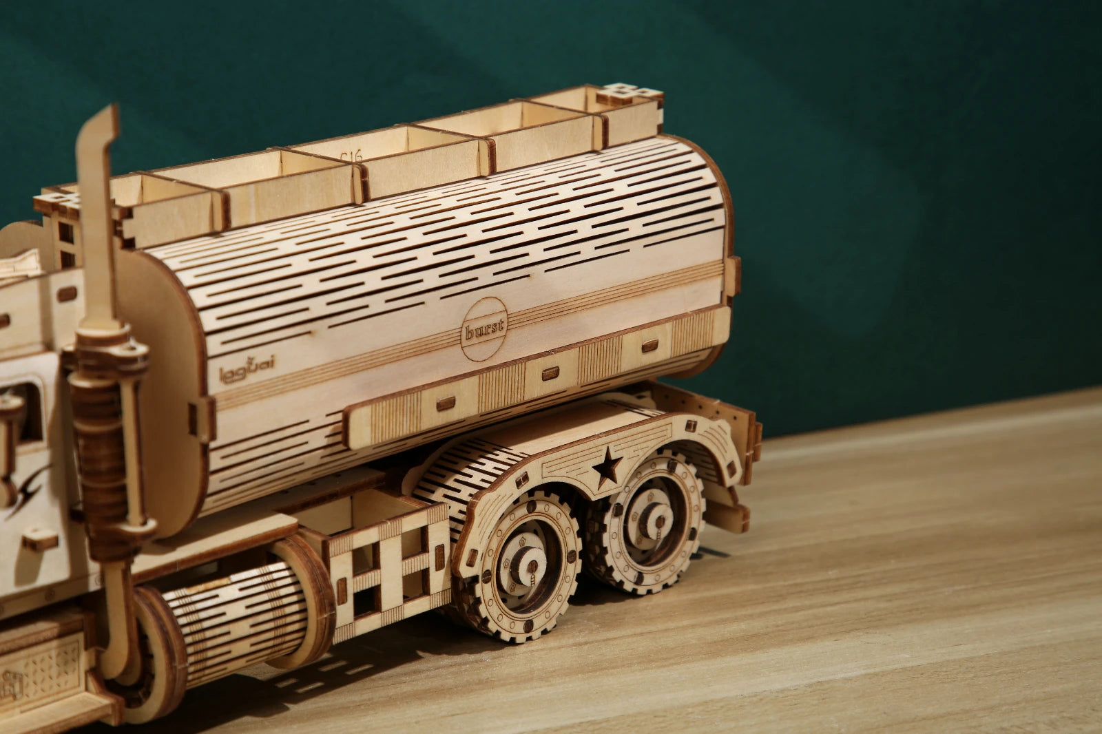 Wooden model of a truck on a wooden surface with a dark green background