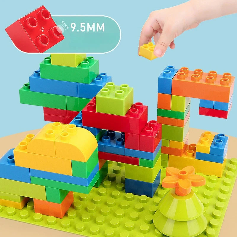 Colorful building blocks being assembled on a green baseplate with a hand adding a yellow block.