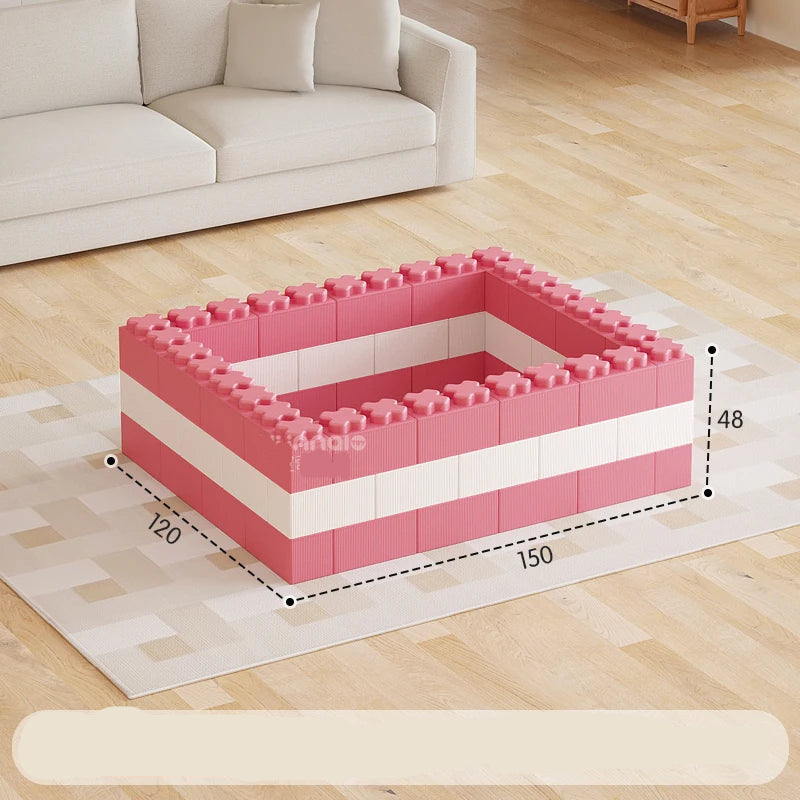 Pink and white foam blocks arranged in a rectangular shape on a wooden floor with a sofa in the background.