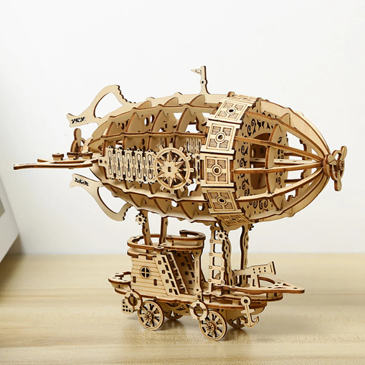 Wooden model of a steampunk airship on a wooden surface with a white background