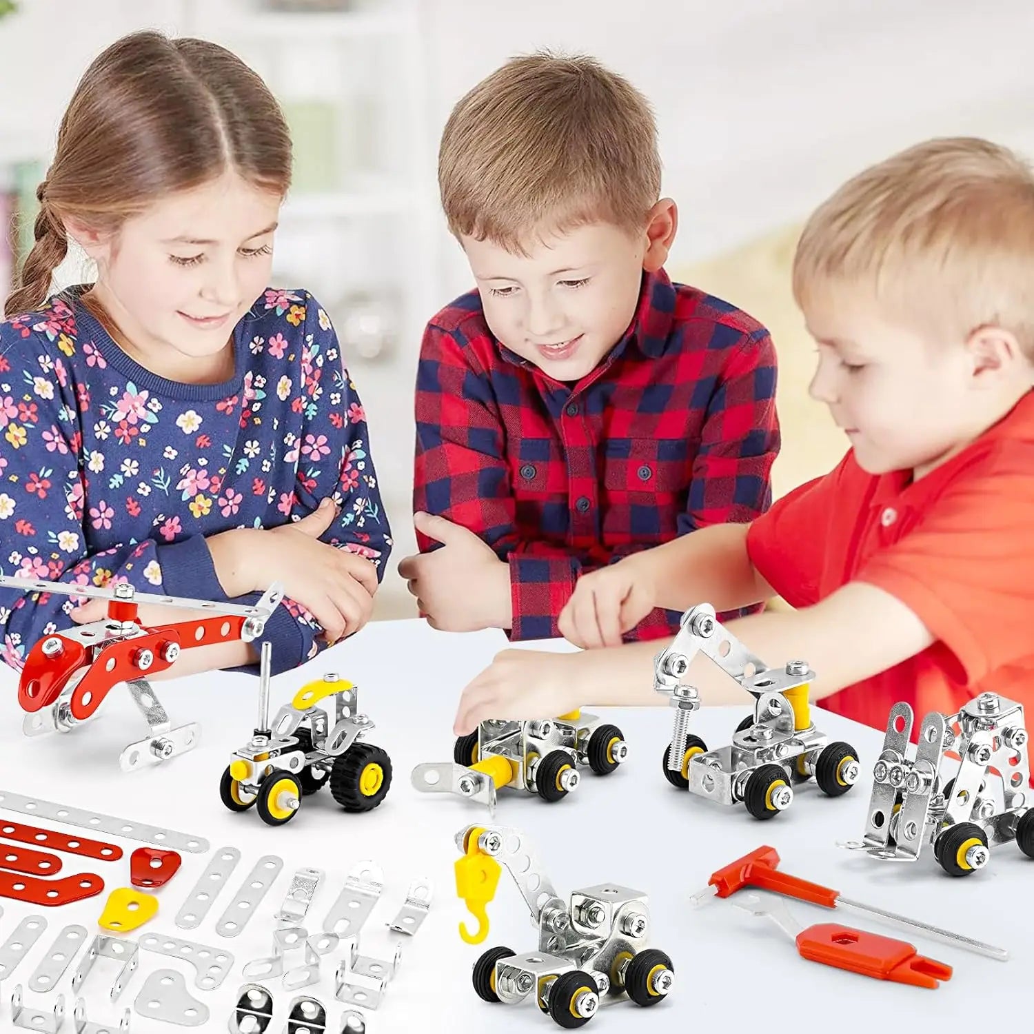 Three children playing with metal construction toys on a table.