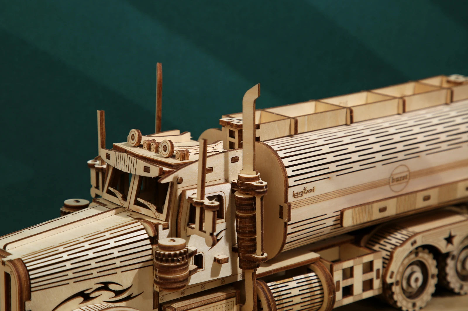 Wooden model of a truck with detailed components on a dark green background