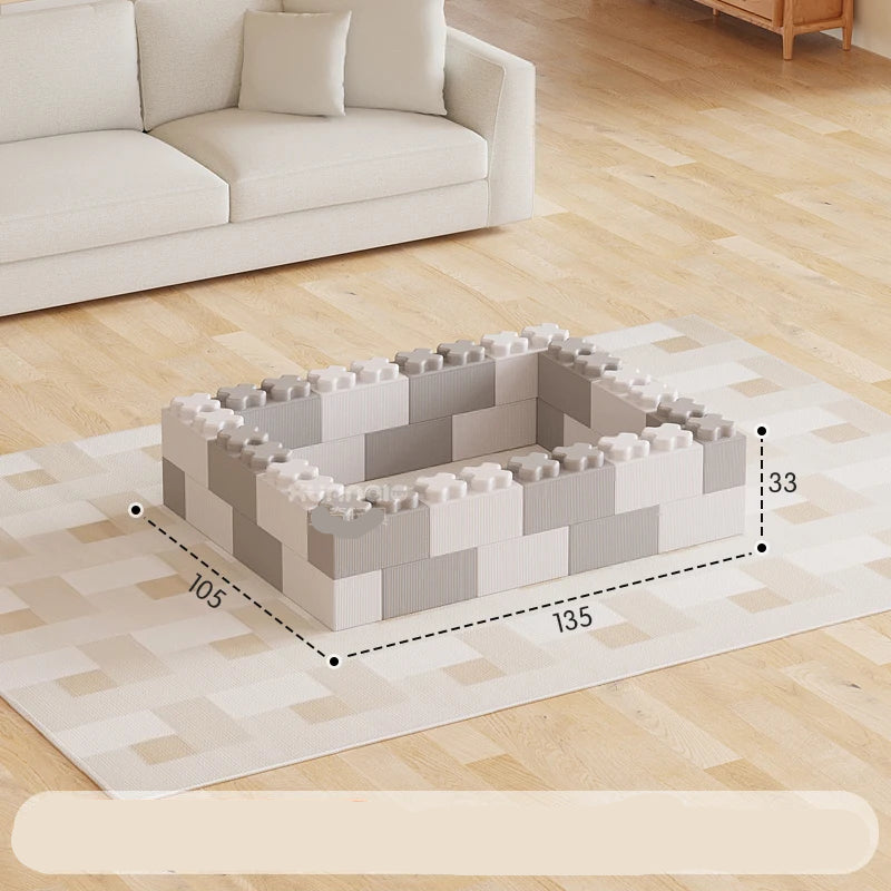 Gray and white foam blocks arranged in a rectangular shape on a wooden floor with a sofa in the background.