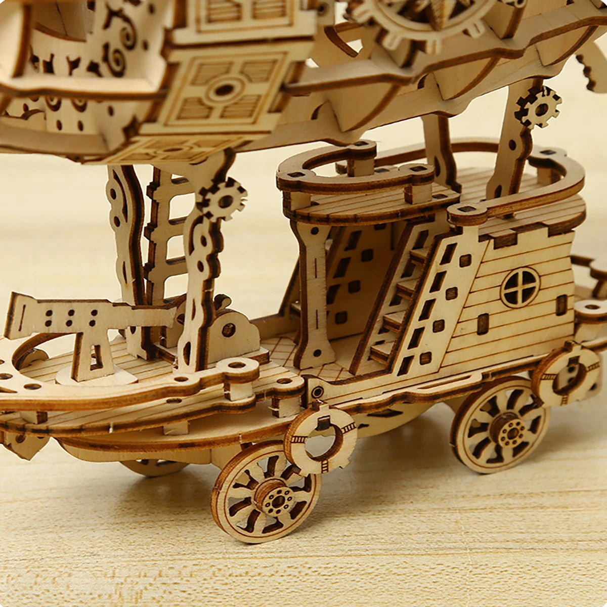 Wooden mechanical model of a ship with intricate details on a wooden surface