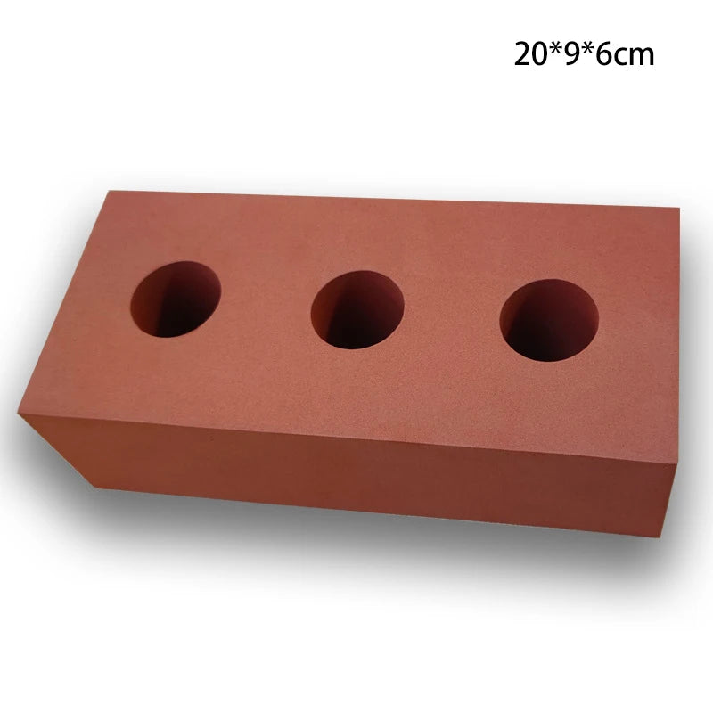 Red brick-shaped object with three circular holes on a white background